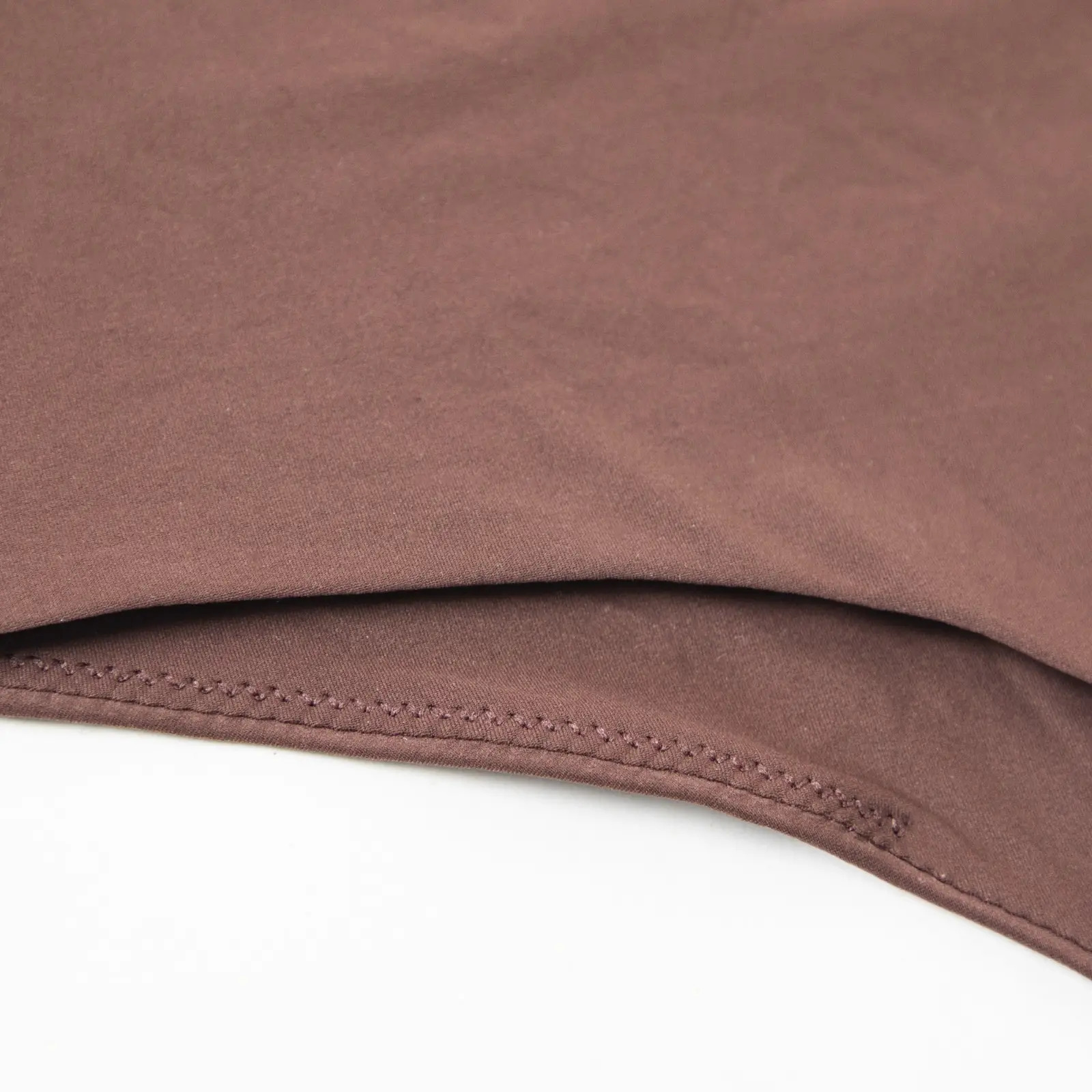 Close-up of brown bodysuit thong bottom fabric.