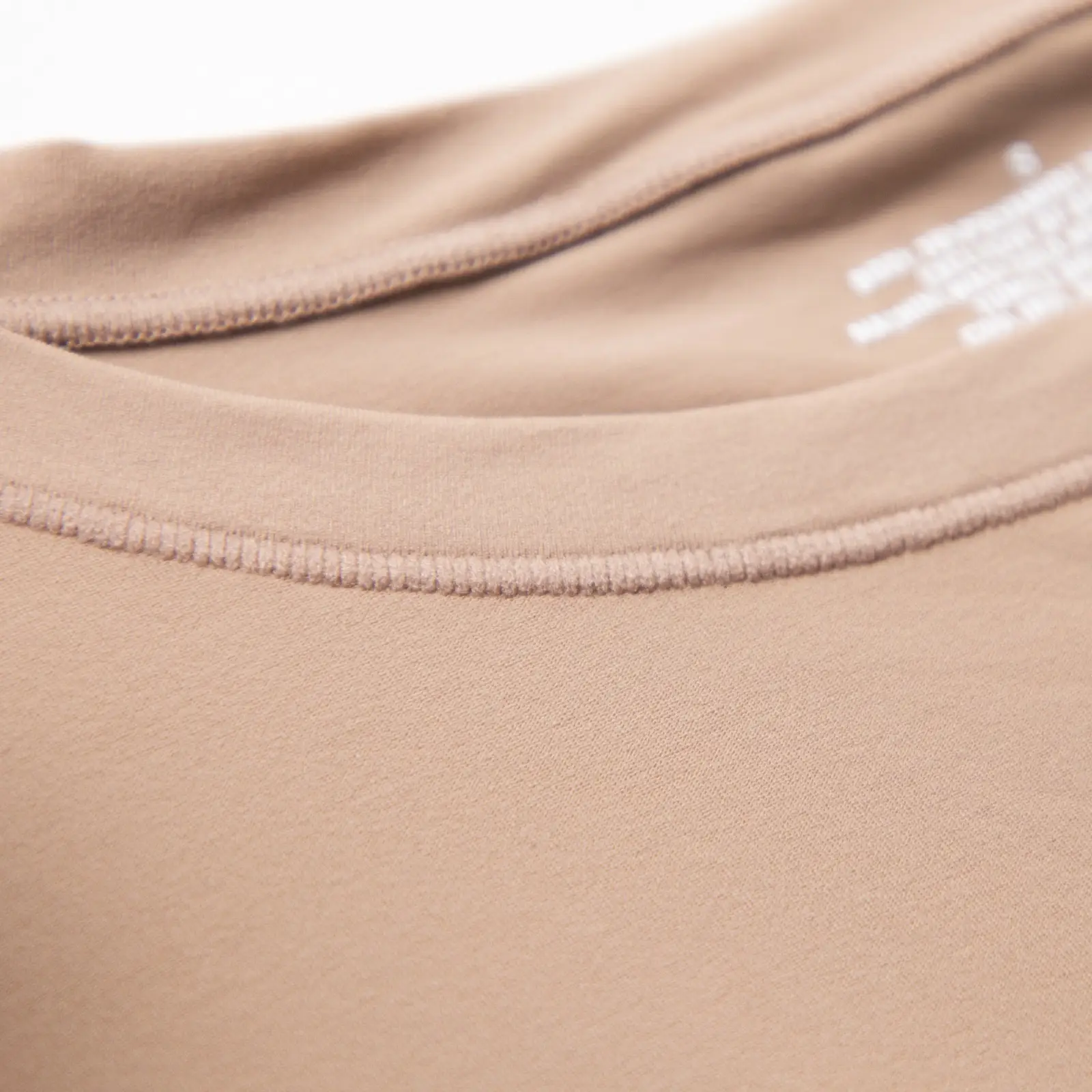 Close-up of crew neck of beige bodysuit