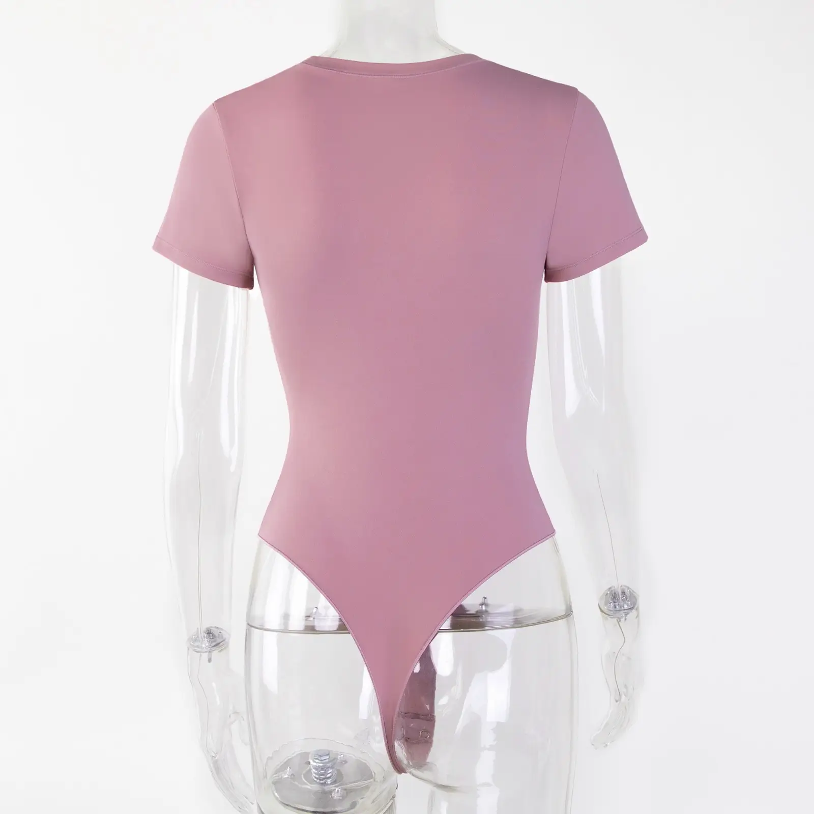 Transparent torso acrylic mannequin wearing a light pink t-shirt bodysuit facing the back over a white background